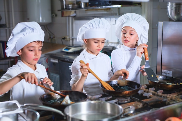 Foto niños cocinando el almuerzo en un restaurante de cocina.