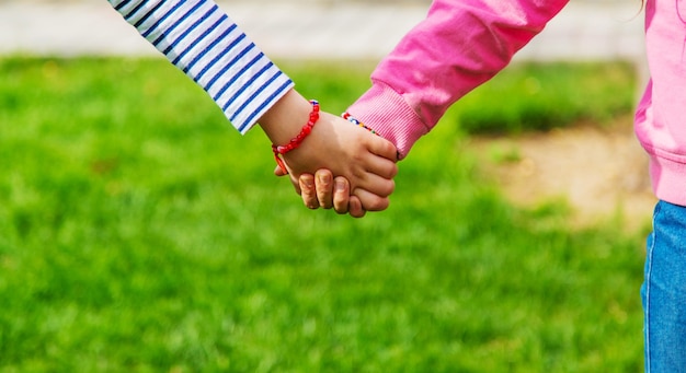 Niños cogidos de la mano en el parqueenfoque selectivo