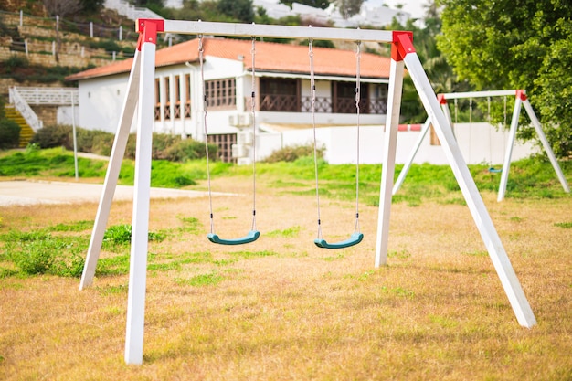 Niños columpios en el patio de recreo