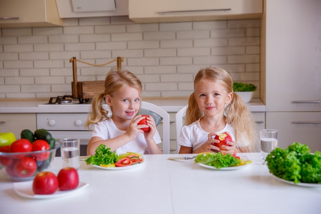 Los niños comen alimentos saludables en la cocina.