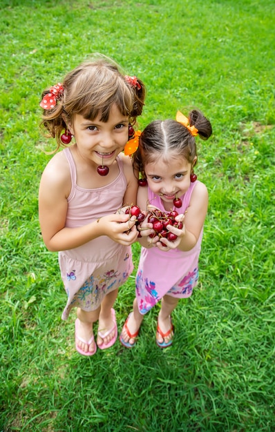 Foto los niños comen cerezas en el verano.