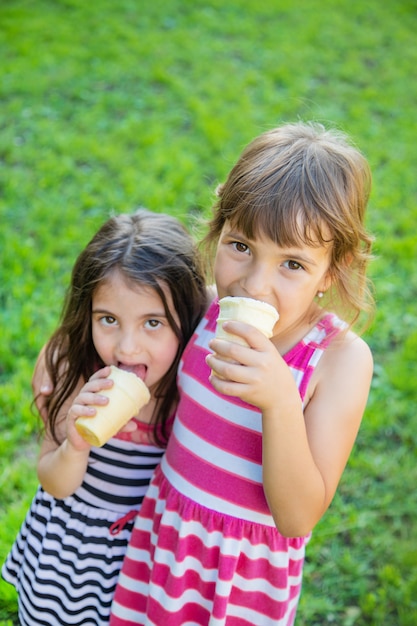 Los niños comen helado en el parque.