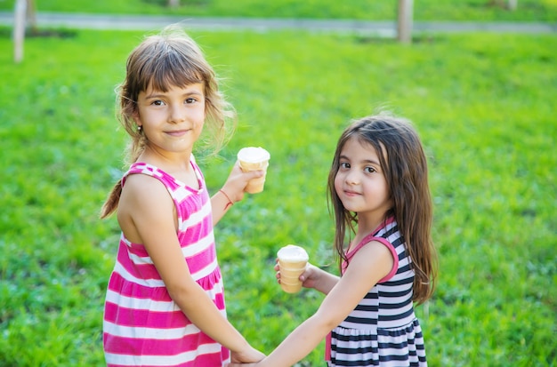 Los niños comen helado en el parque.