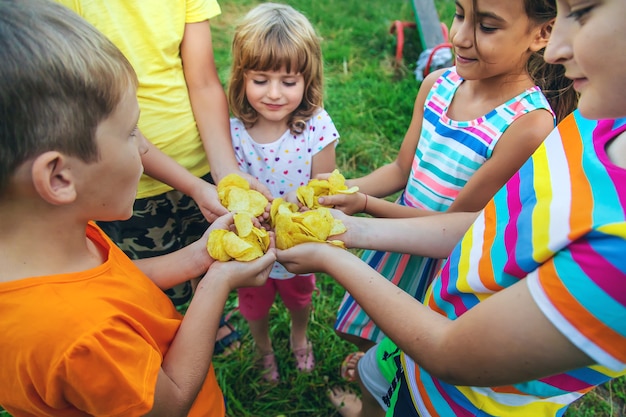 Los niños comen patatas fritas en la calle. Enfoque selectivo. Comida.