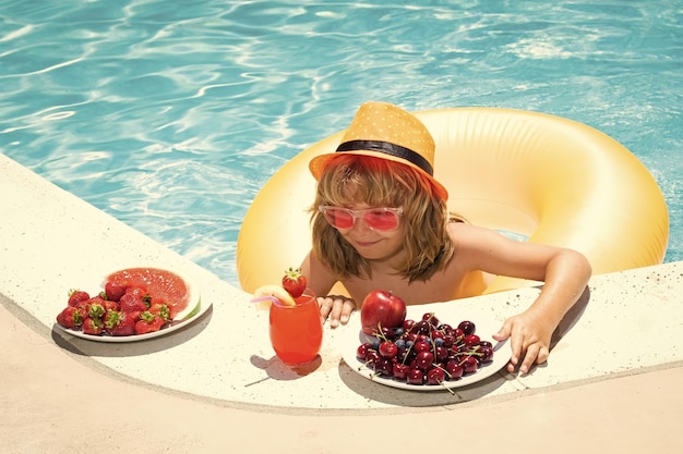 Niños comiendo frutas cerca de la piscina durante las vacaciones de verano niños comen frutas al aire libre saludables