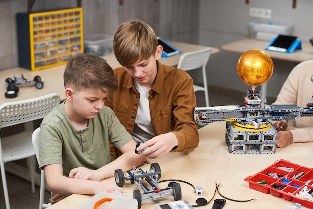 Niños construyendo el coche en equipo.