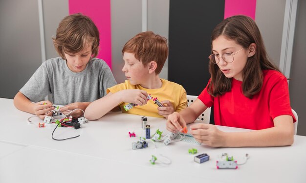 Niños construyendo robots electrónicos en el aula.