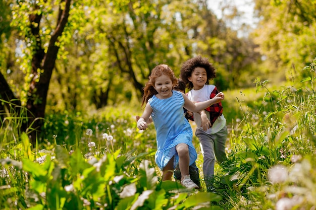 Foto niños corriendo en el parque y sintiéndose emocionados.