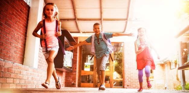 Niños corriendo en el pasillo de la escuela.