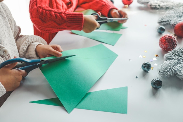 Niños cortando papel idea de actividad navideña