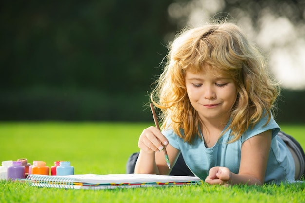 Los niños crean pinturas de artistas creatividad vacaciones escolares niños dibujando en el parque de verano pintando arte