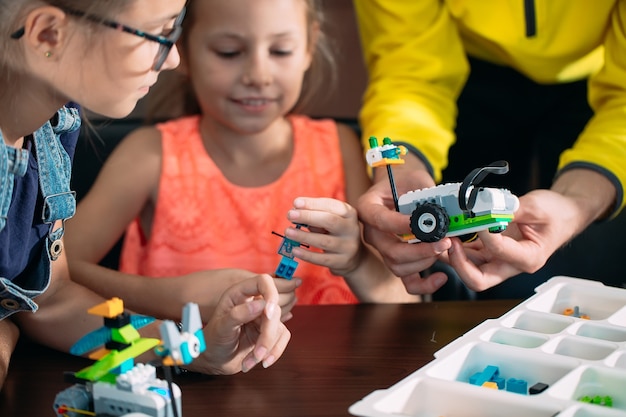 Niños creando robots con el maestro.