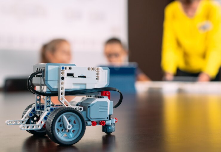 Foto niños creando robots con el maestro.