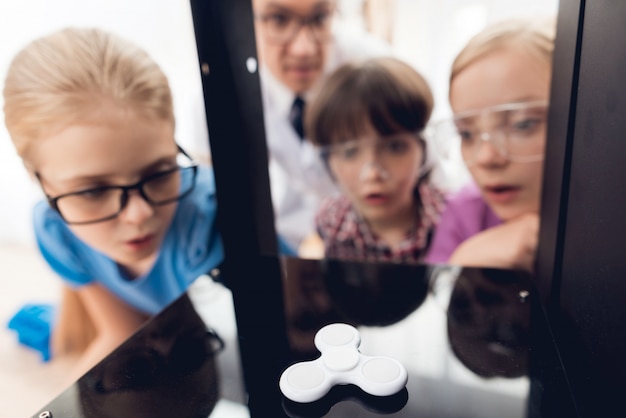 Niños curiosos con gafas mirando al hilandero.