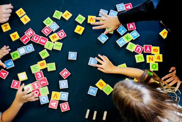 Niños deletreando palabras con bloques del alfabeto