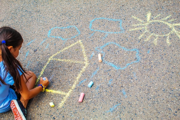 Los niños dibujan la casa de la bandera ucraniana en el pavimento Enfoque selectivo
