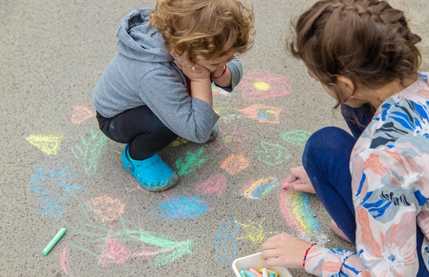 Los niños dibujan con tiza en el pavimento Enfoque selectivo