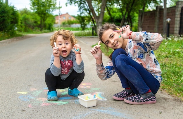 Los niños dibujan con tiza en el pavimento Enfoque selectivo