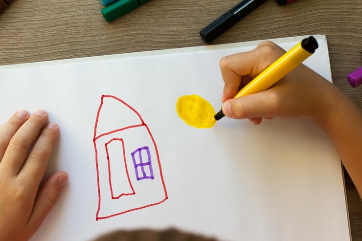 Foto niños dibujando en acuarela la casa de sus sueños