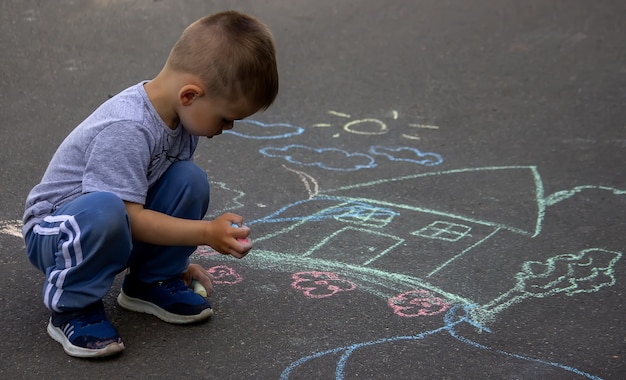 Niños dibujando en casa familiar de asfalto. Enfoque selectivo