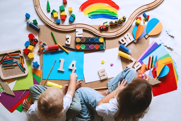 Niños dibujando y haciendo artesanías en el jardín de infantes o guardería Niños pequeños con juguetes educativos y suministros para la creatividad Niños educación y desarrollo en preescolar o guardería