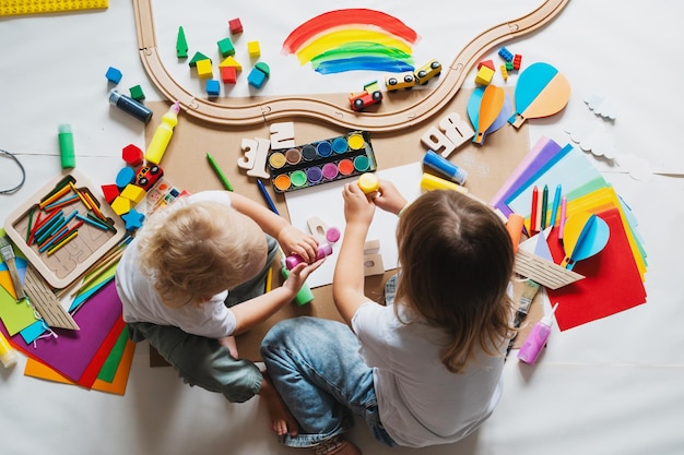 Foto niños dibujando y haciendo artesanías en el jardín de infantes o en la guardería