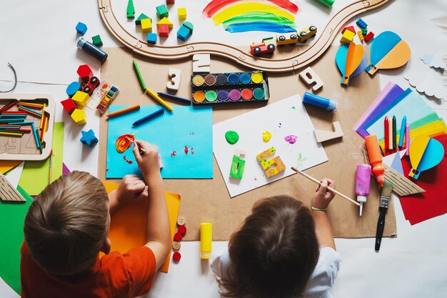 Foto niños dibujando y haciendo artesanías en el jardín de infantes o en la guardería