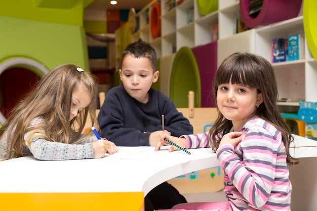 Niños dibujando en la sala de juegos.