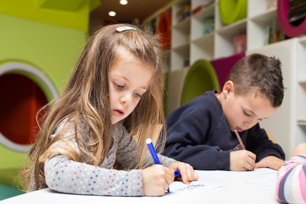 Niños dibujando en la sala de juegos.