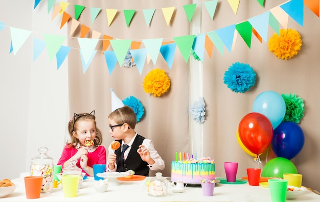 Foto los niños discuten qué dulces son más deliciosos en la fiesta de cumpleaños.