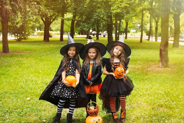 Foto niños en disfraces de halloween con calabaza engañados en vacaciones