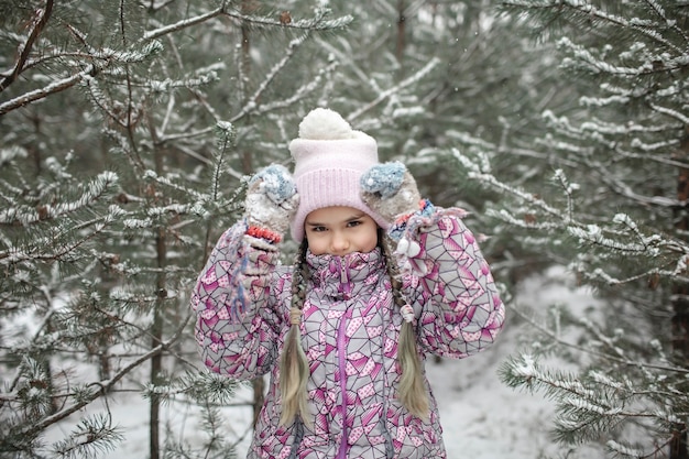 Los niños disfrutan de la primera nieve en el bosque de invierno, actividades de temporada activas, estilo de vida