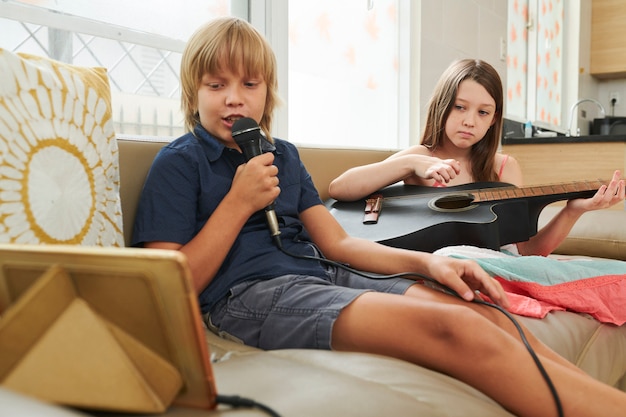 Niños disfrutando de karaoke en casa.