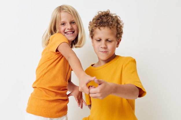 Niños divertidos cogidos de la mano chico y chica posando