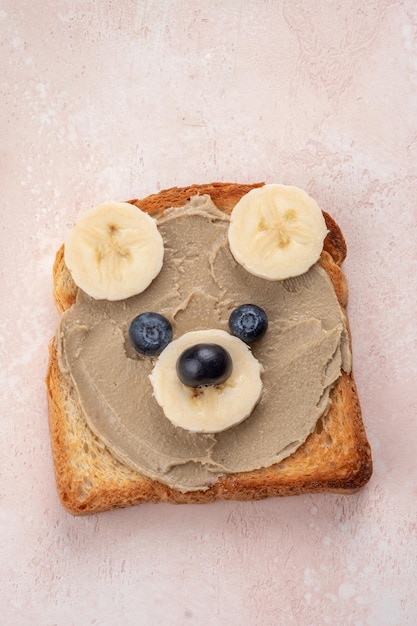 Los niños divertidos llevan tostadas con mantequilla solar o mantequillas de nueces para el desayuno