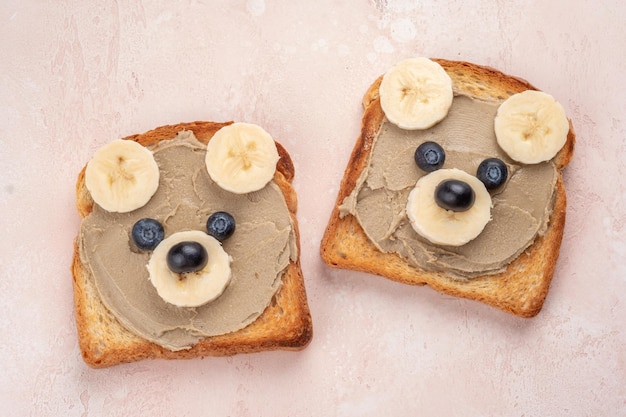 Los niños divertidos llevan tostadas con mantequilla solar o mantequillas de nueces para el desayuno