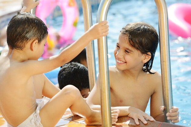 Los niños se divierten jugando con agua en la piscina de verano