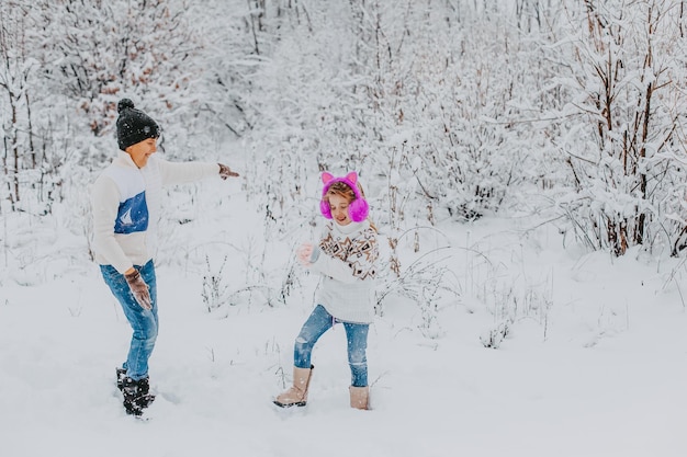 Los niños se divierten jugando en la nieve. niño y niña corriendo en Winter Park. vacaciones de invierno