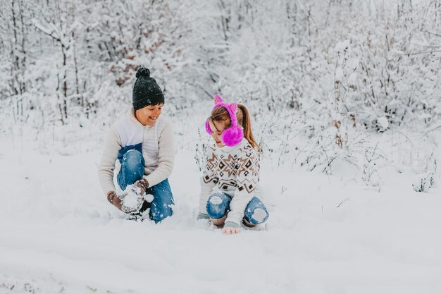 Los niños se divierten jugando en la nieve. niño y niña corriendo en Winter Park. vacaciones de invierno