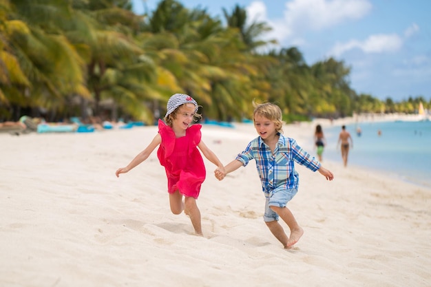 Niños divirtiéndose corriendo juntos en la playa.