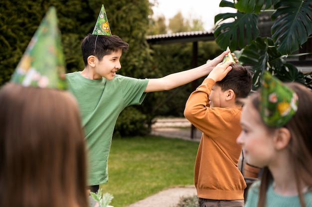 Foto niños divirtiéndose en la fiesta temática de la jungla