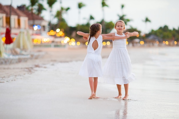 Niños divirtiéndose en la playa tropical bailando y divirtiéndose