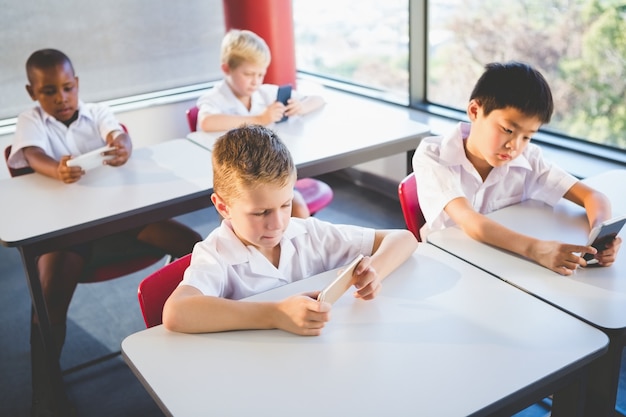 Niños en edad escolar mediante teléfono móvil en el aula