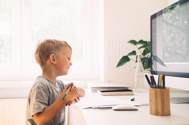 Niños en edad preescolar que usan tecnología informática en el desarrollo temprano o entretenimiento en el hogar Educación en el hogar para niños y educación en línea a distancia Niño que estudia o crea en el escritorio Aprendizaje en línea para niños