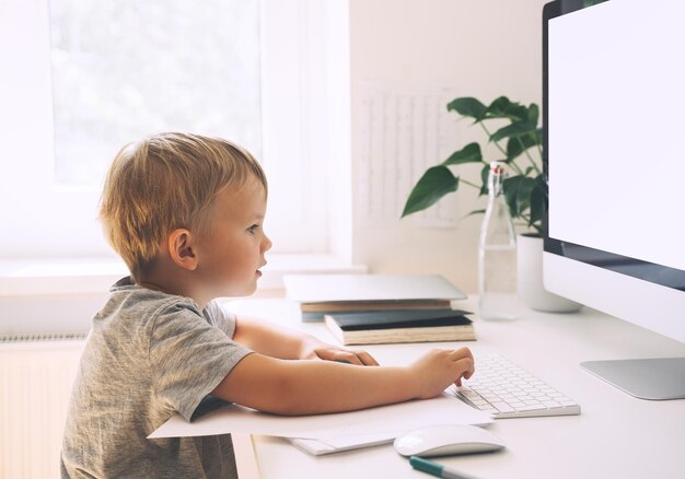 Niños en edad preescolar que usan tecnología informática en el desarrollo temprano o entretenimiento en el hogar Educación en el hogar para niños y educación en línea a distancia Niño que estudia o crea en el escritorio Aprendizaje en línea para niños