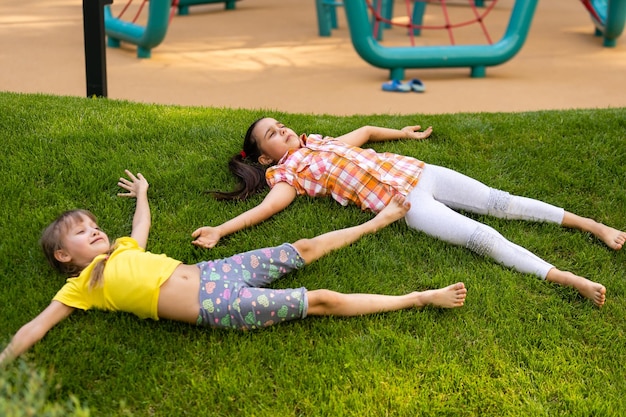 Niños emocionados felices divirtiéndose juntos en el patio de recreo