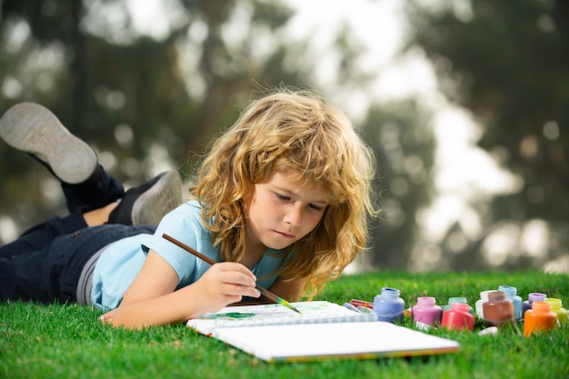 Niños escolares dibujando en el parque de verano pintura arte pequeño pintor dibujar dibujos niños al aire libre crea