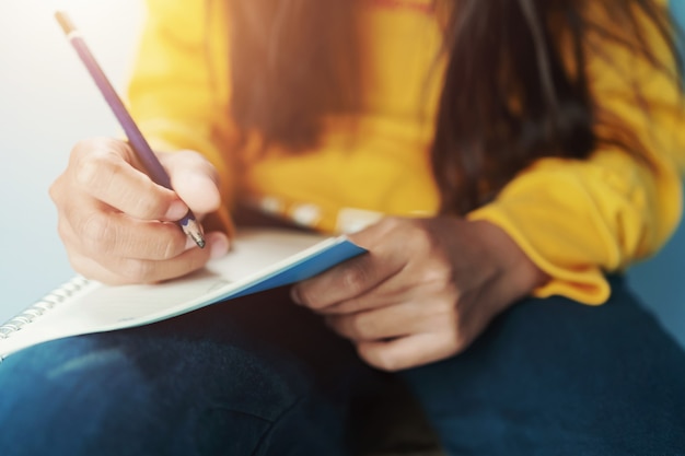 Niños escribiendo en el cuaderno a lápiz