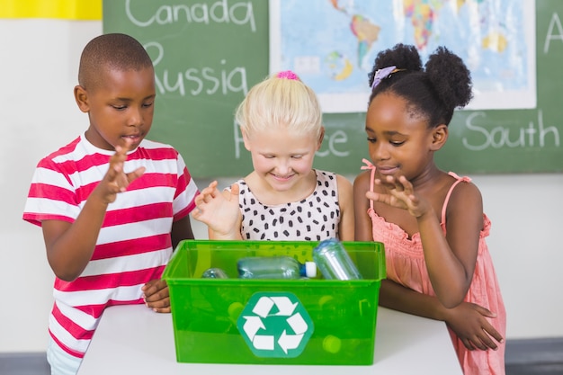 Niños de la escuela buscando reciclar cuadro de logotipo en el aula