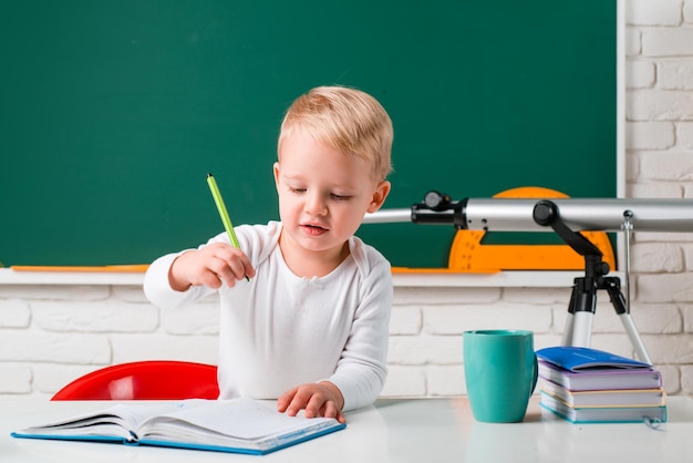 Niños de la escuela contra la pizarra verde pequeño estudiante feliz con una excelente marca feliz lindo indu